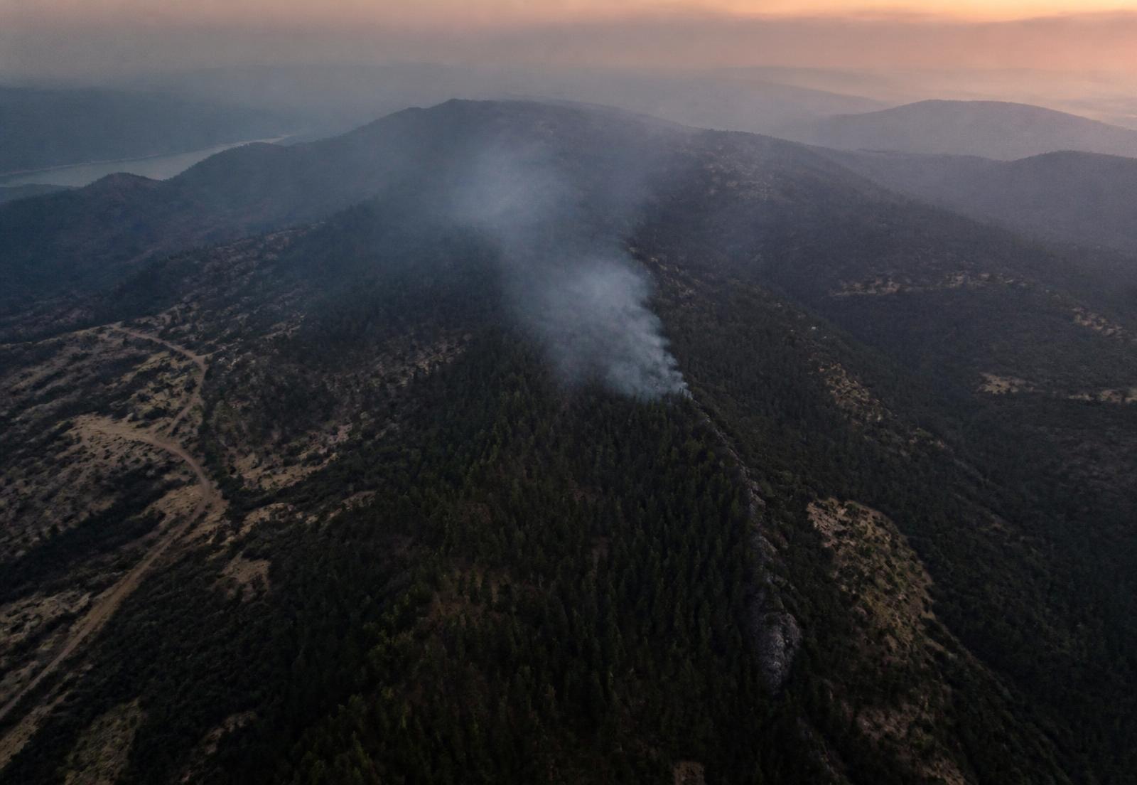 Aerial optical view of a forested ridge with early smoke